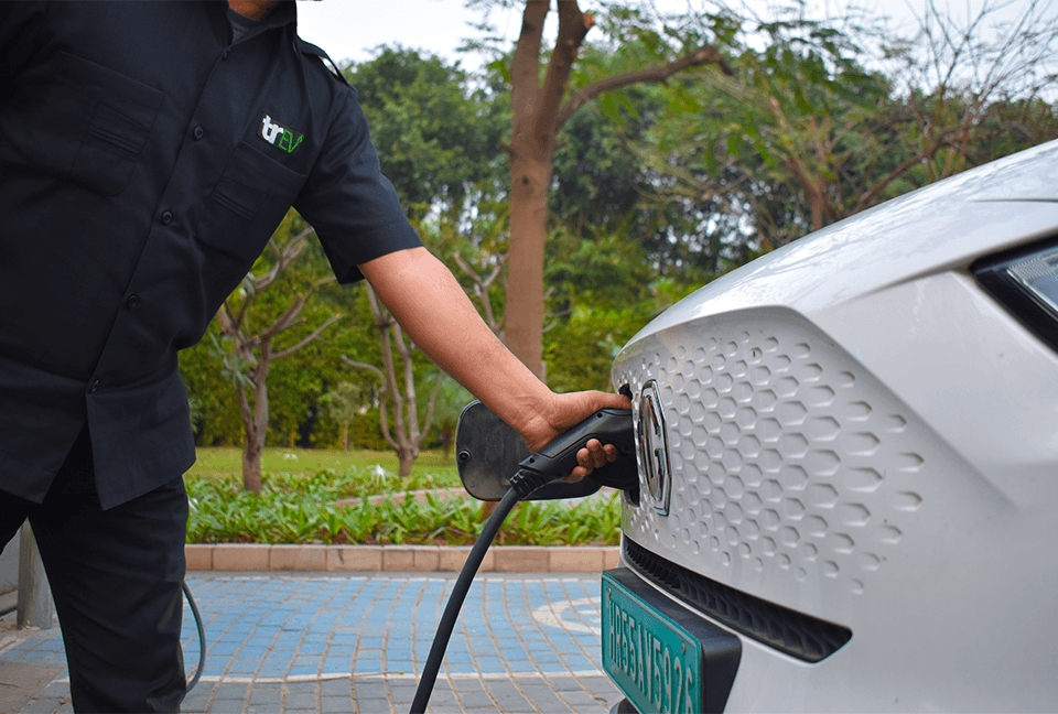 TrEV chauffeur charging a white electric vehicle